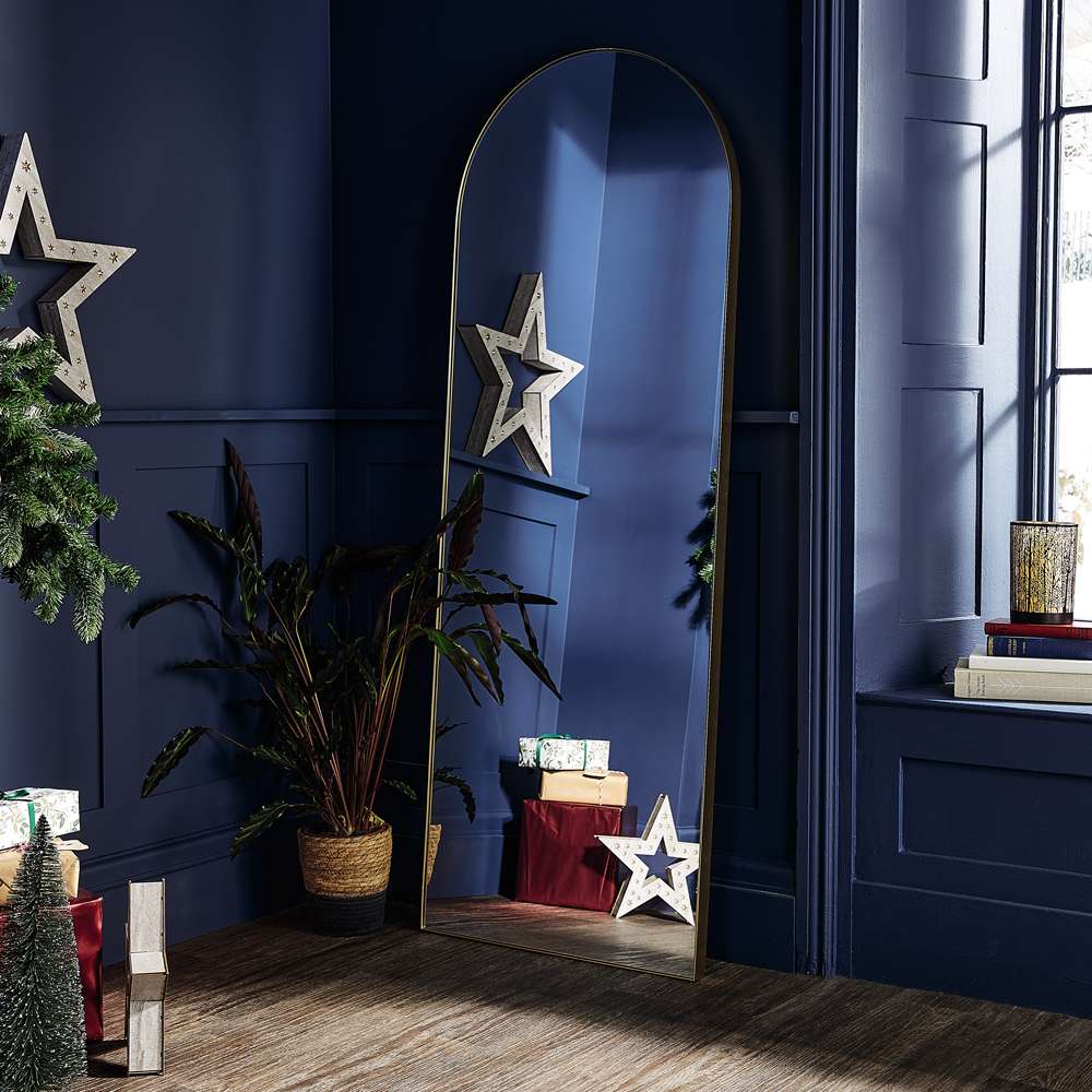 مرآة ذهبية قوسية من ألدي في غرفة الأعياد باللون الأزرق الداكن