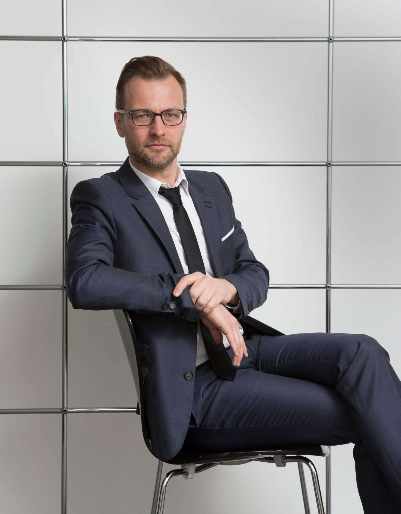 صورة شخصية لرجل جالس وذراعه اليمنى ملفوفة