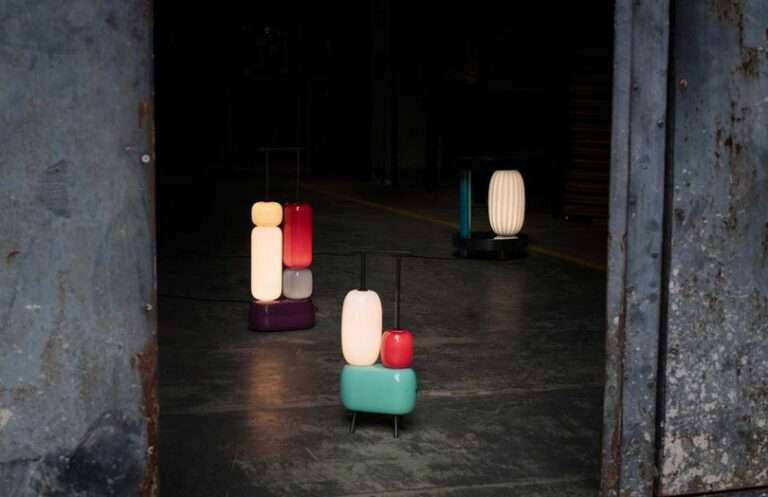 ثلاثة مصابيح ملونة منحوتة مضاءة على خلفية مظلمة