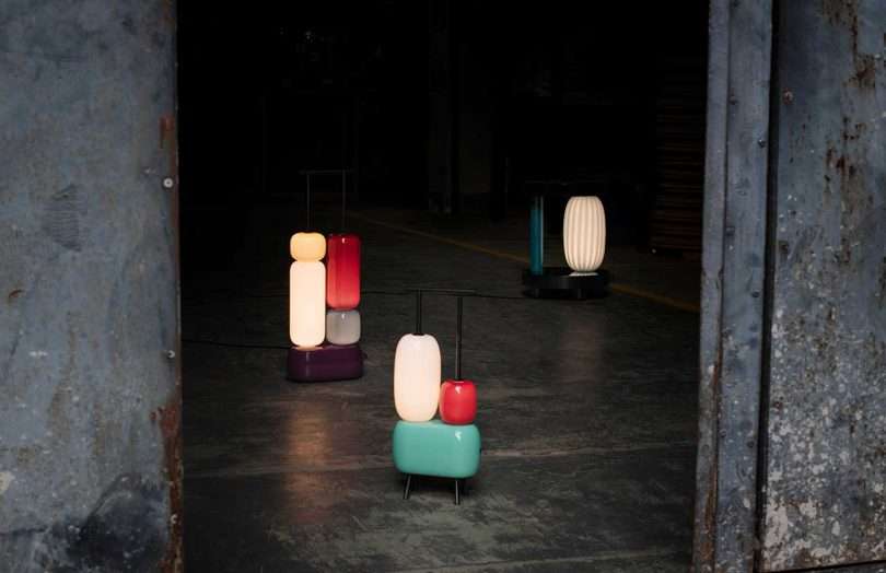 ثلاثة مصابيح ملونة منحوتة مضاءة على خلفية مظلمة