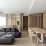 يستخدم التصميم الداخلي الحديث للشقة أقسامًا منحنية من خشب البلوط لإنشاء مناطق.