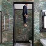a self-portrait by maurizio cattelan hangs in the bathroom of milan’s massimo de carlo gallery