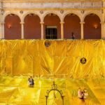golden sheet made out of emergency blankets covers 16th-century convent patio in spain