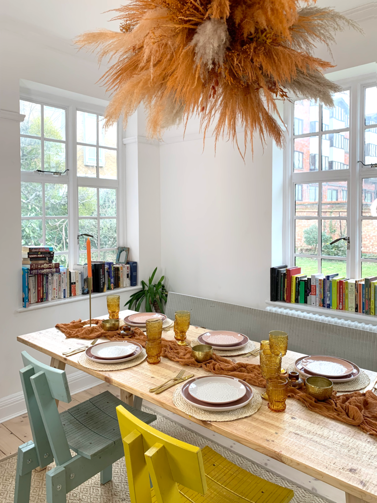 تتدلى سحابة برتقالية وتان بامباس فوق طاولة طعام رسمية.