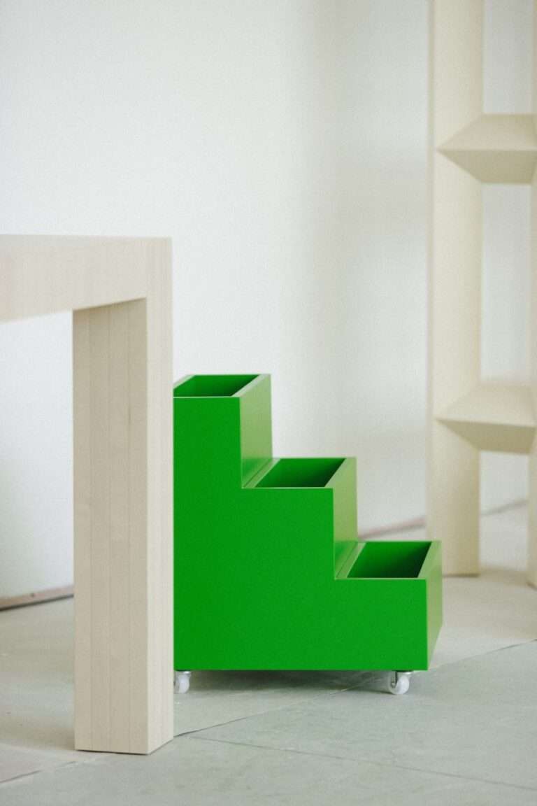 طاولة ، خزانة كتب متدرجة ، وخزانة كتب في مساحة بيضاء