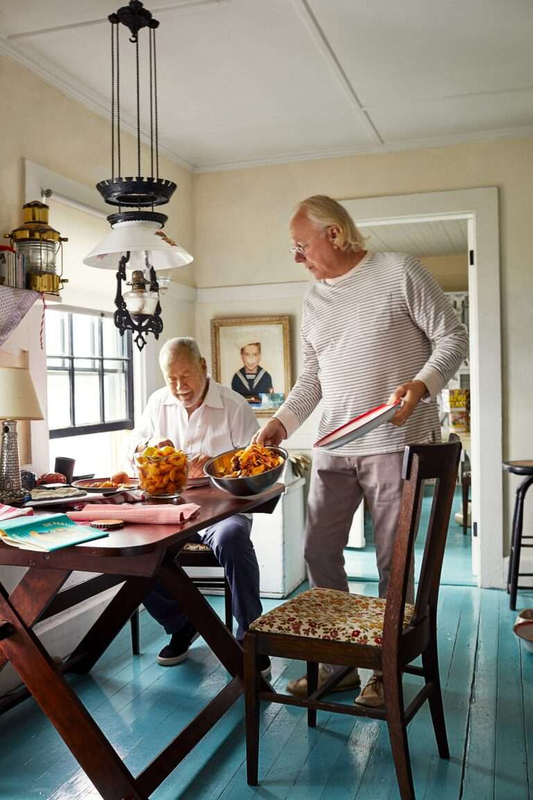 رجلين على طاولة المطبخ طاولة خشبية كرسي خشبي ونافذة أرضية زرقاء تركيبات إضاءة