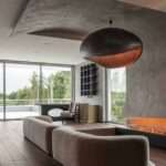 A Curved Accent Wall Wraps Around From The Fireplace To The Ceiling Inside This Home