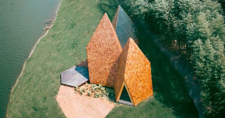 wooden shingles overlay cluster of monolithic cabins on chinese waterfront