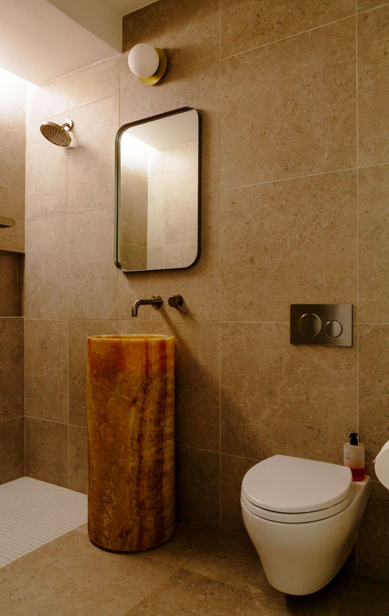 يحتوي حمام الضيوف على مغسلة مخصصة من العقيق وصابون لليدين من Byredo.