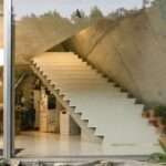 studeny architekti embeds concrete shell house into a hillside in pernek, slovakia