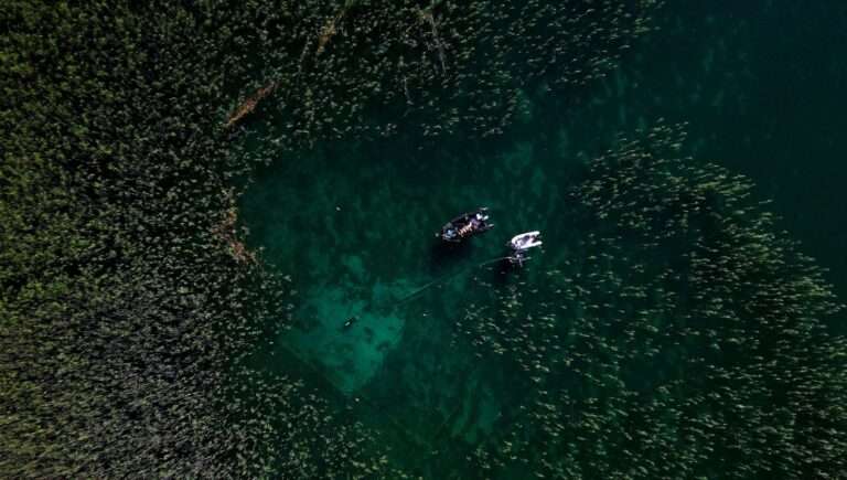 aerial photo of diver exploring submerged ancient village of Lin