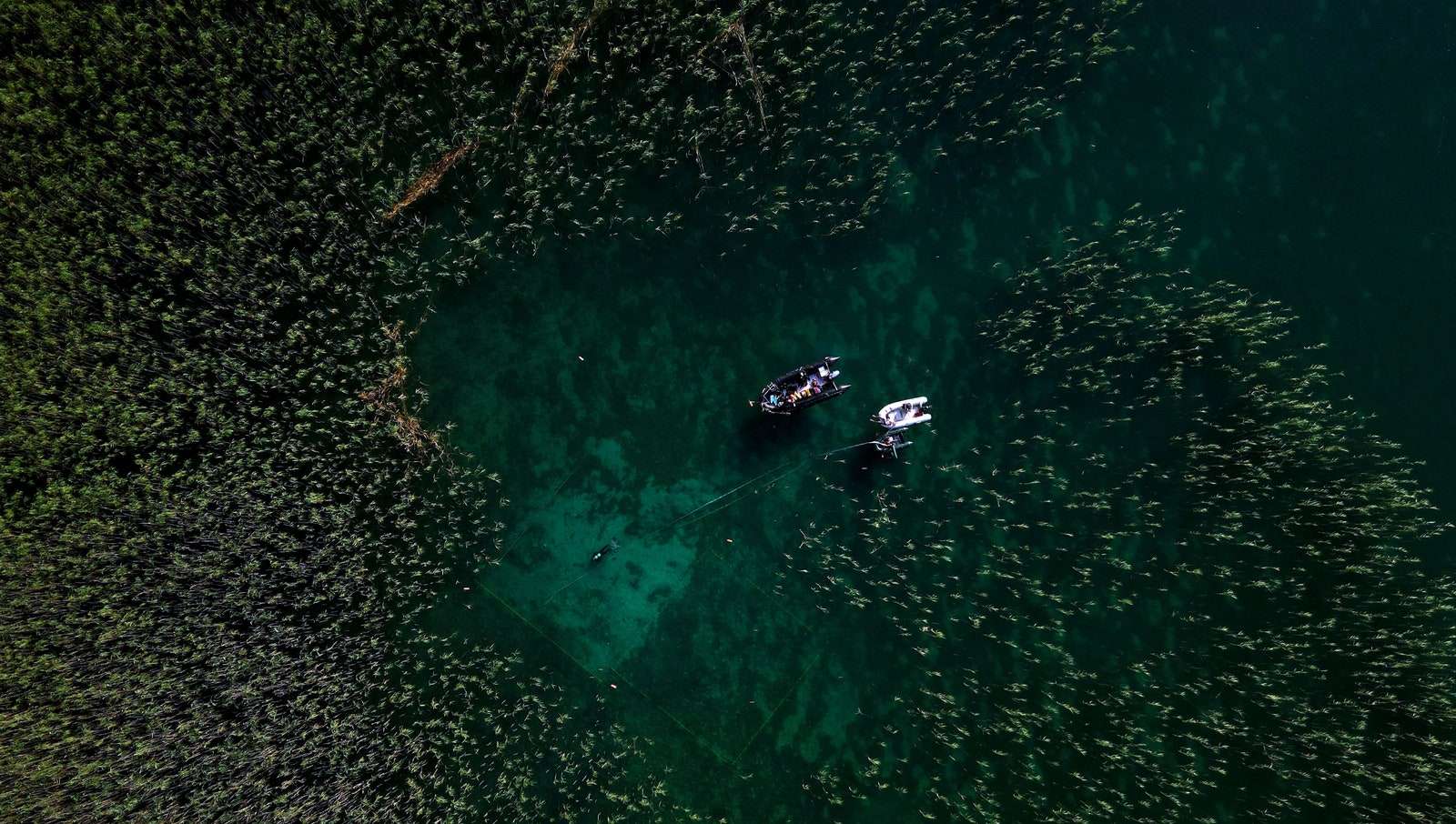 aerial photo of diver exploring submerged ancient village of Lin