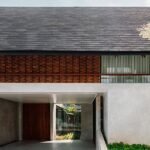 red brick lace-like facade coats the mass of ach house in south jakarta