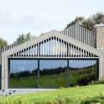 cluster of pitched timber volumes by coffey architects perch above dorset’s sloping hillside