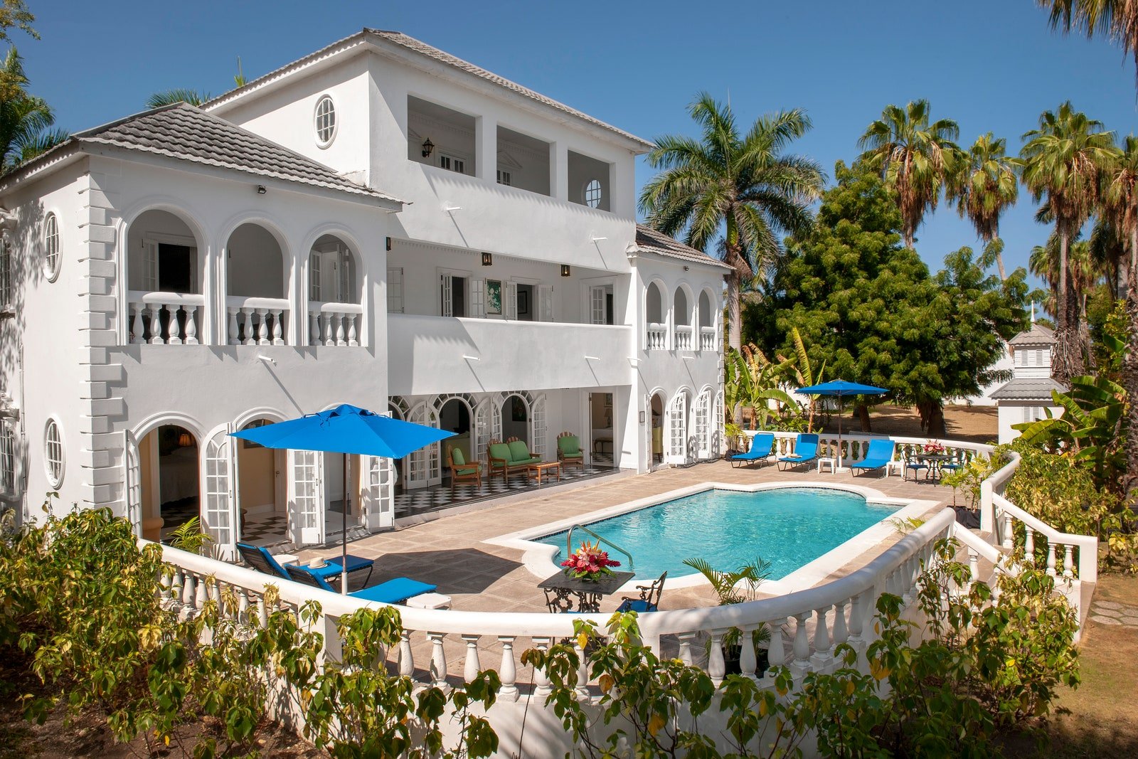 a white house with a pool and palm trees