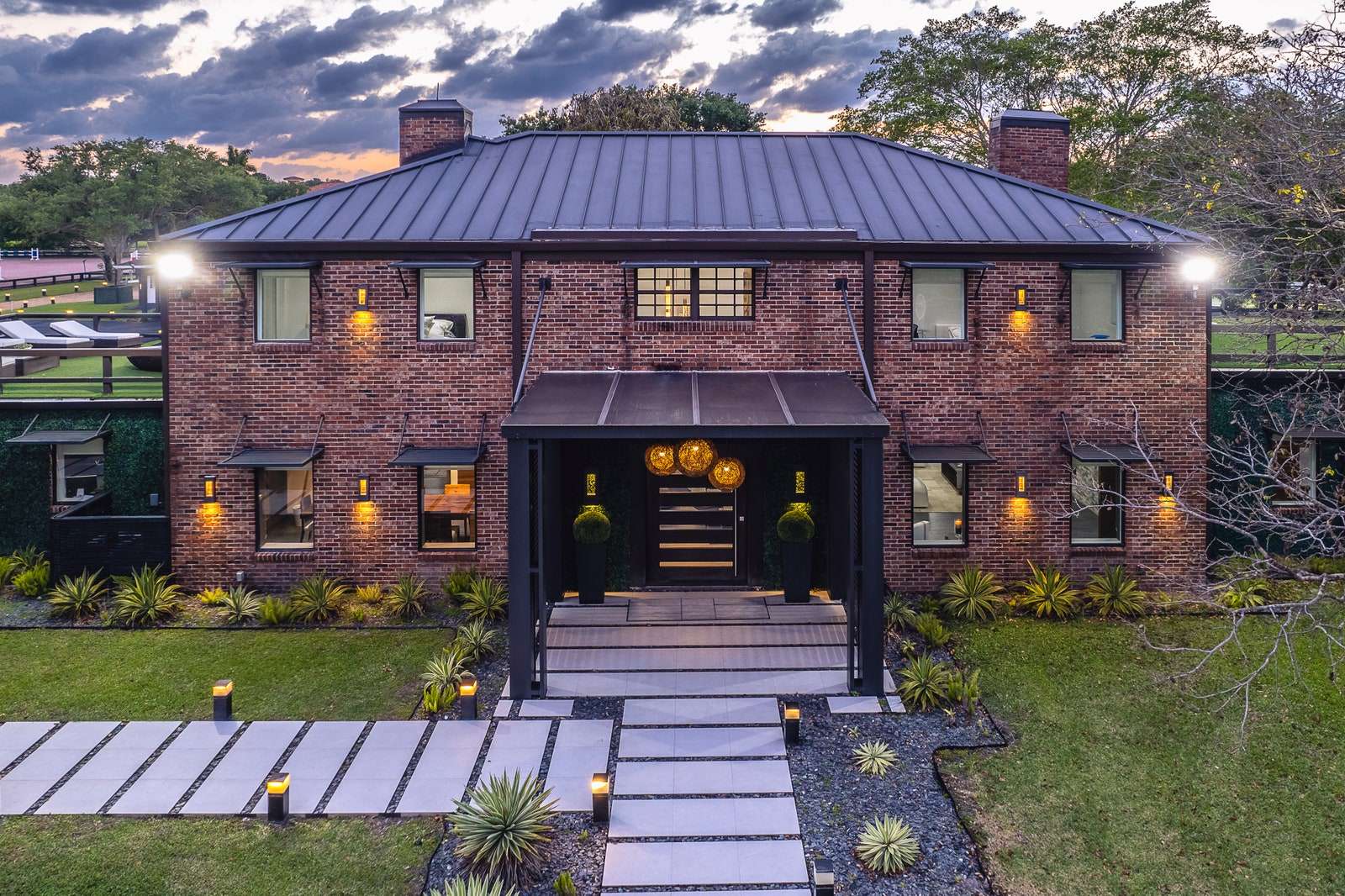 Gisele Bündchens new home a red brick estate with a gray path leading to door