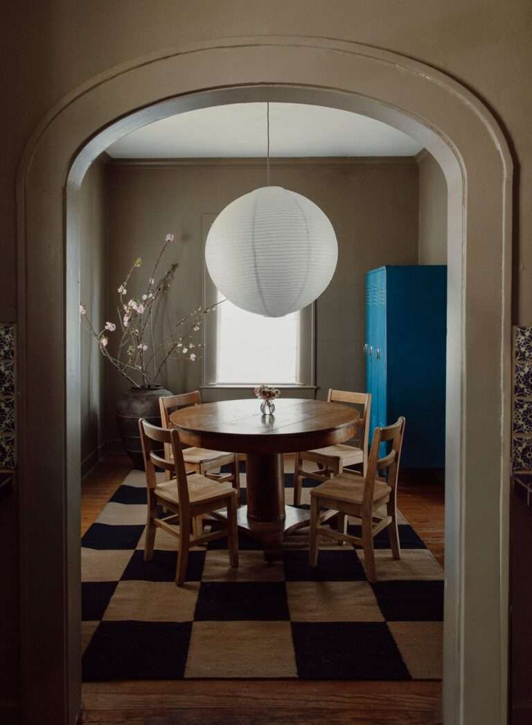 An antique oak pedestal table and vintage American school chairs ground the dining room in a sturdy craftsman style...