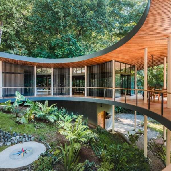 A modern circular off-grid home that's raised up on stilts.