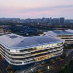 aluminum facade contrasts with organic garden in iFLYTEK AI headquarters by line+