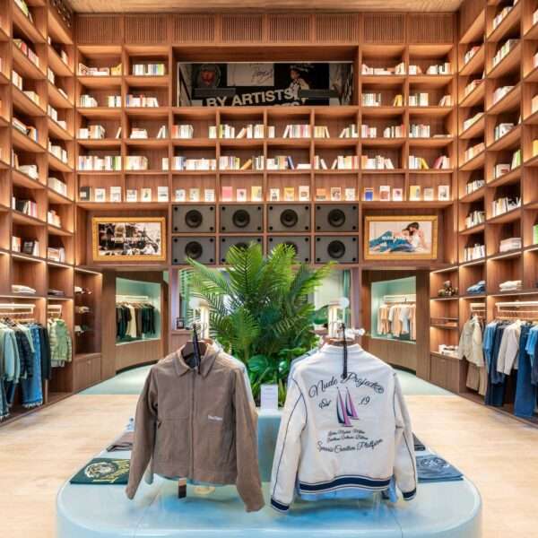 A modern streetwear retail store with 19-foot-high wooden bookshelves, a DJ booth, and a fitting room with baby blue accents.
