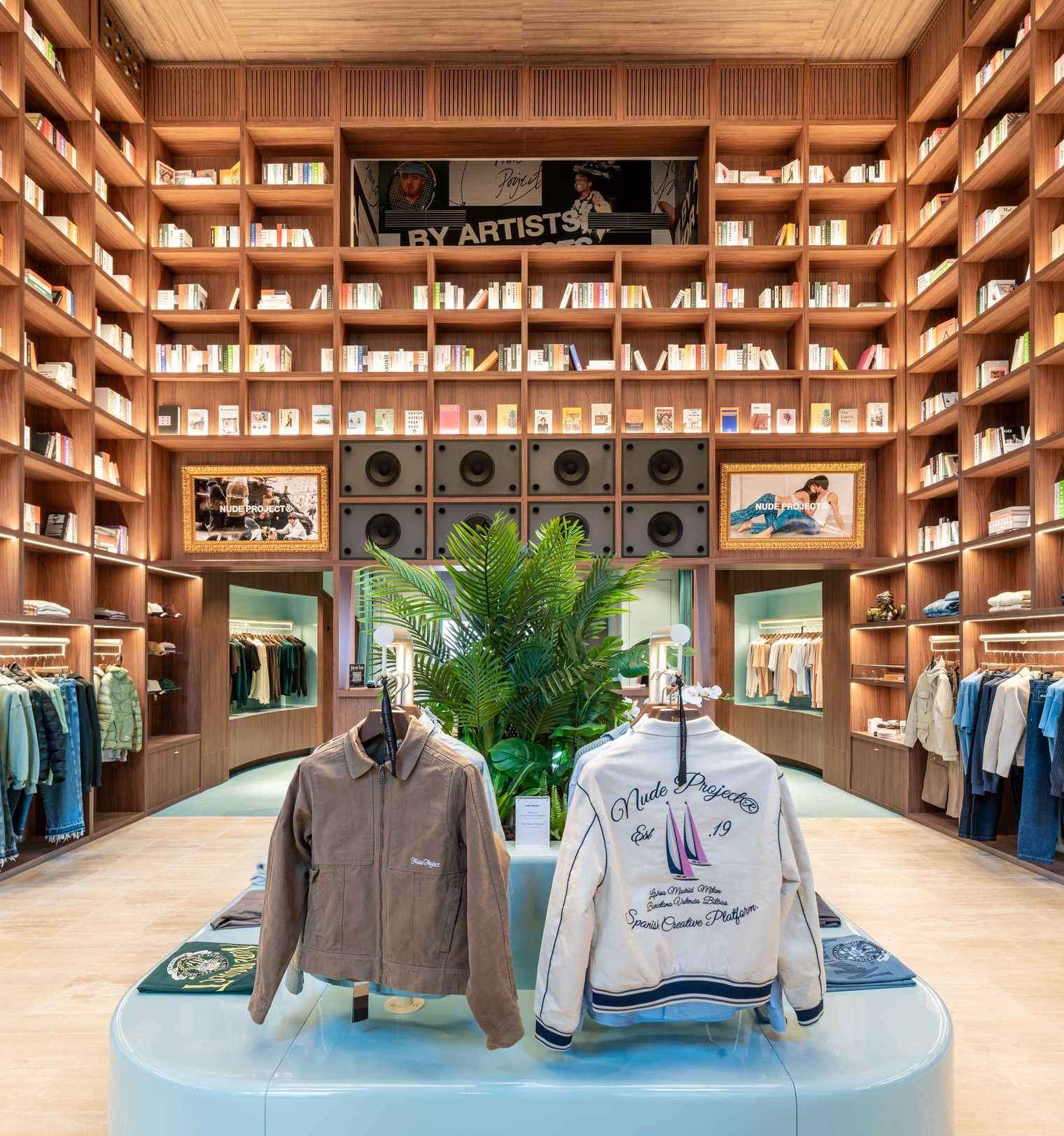 A modern streetwear retail store with 19-foot-high wooden bookshelves, a DJ booth, and a fitting room with baby blue accents.