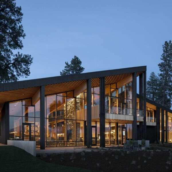 A modern ranch lodge with a black charred cedar exterior (shou sugi ban) and a warm wood interior.