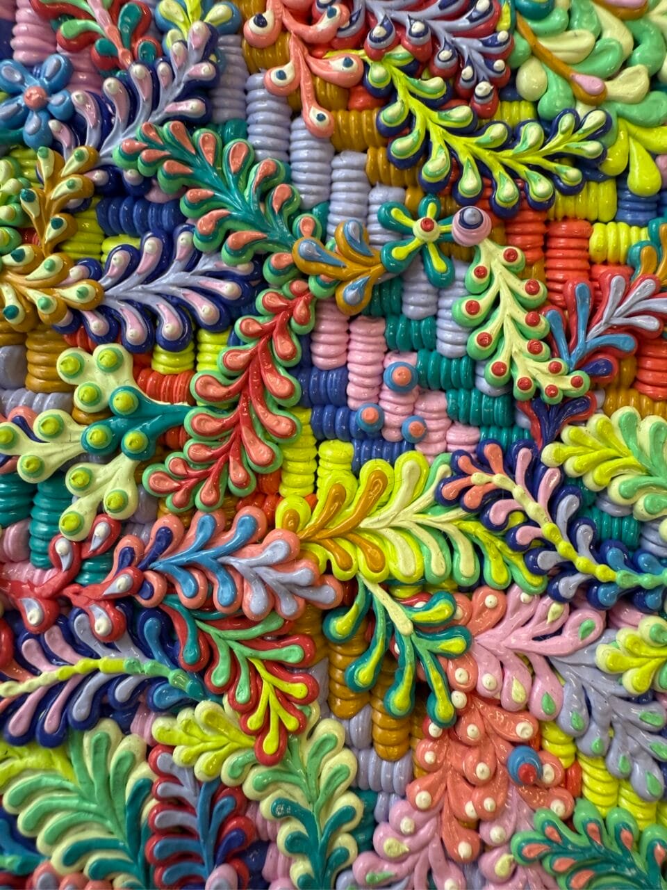 a detail of a highly textured oil painting in a multi-colored floral pattern