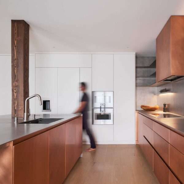 This modern kitchen in a renovated historic loft, features striking copper cabinetry and a stainless steel countertop.