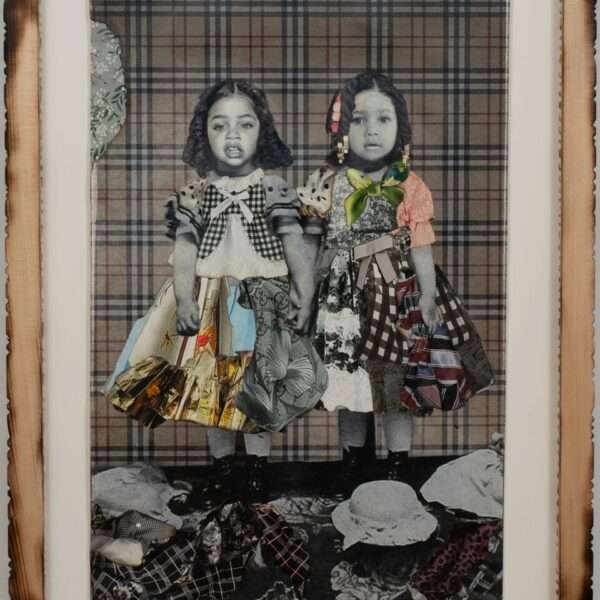 a collage of black and white photos and colorful textiles in a carved wooden frame. the photo depicts two little girls