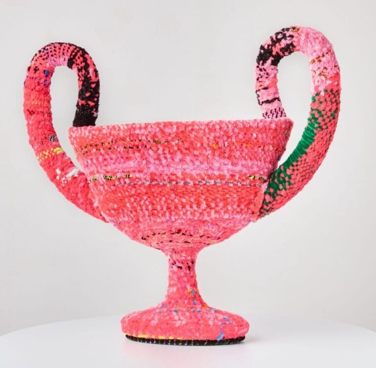 a vessel made from woven pipe cleaners in shades of pink and pops of green