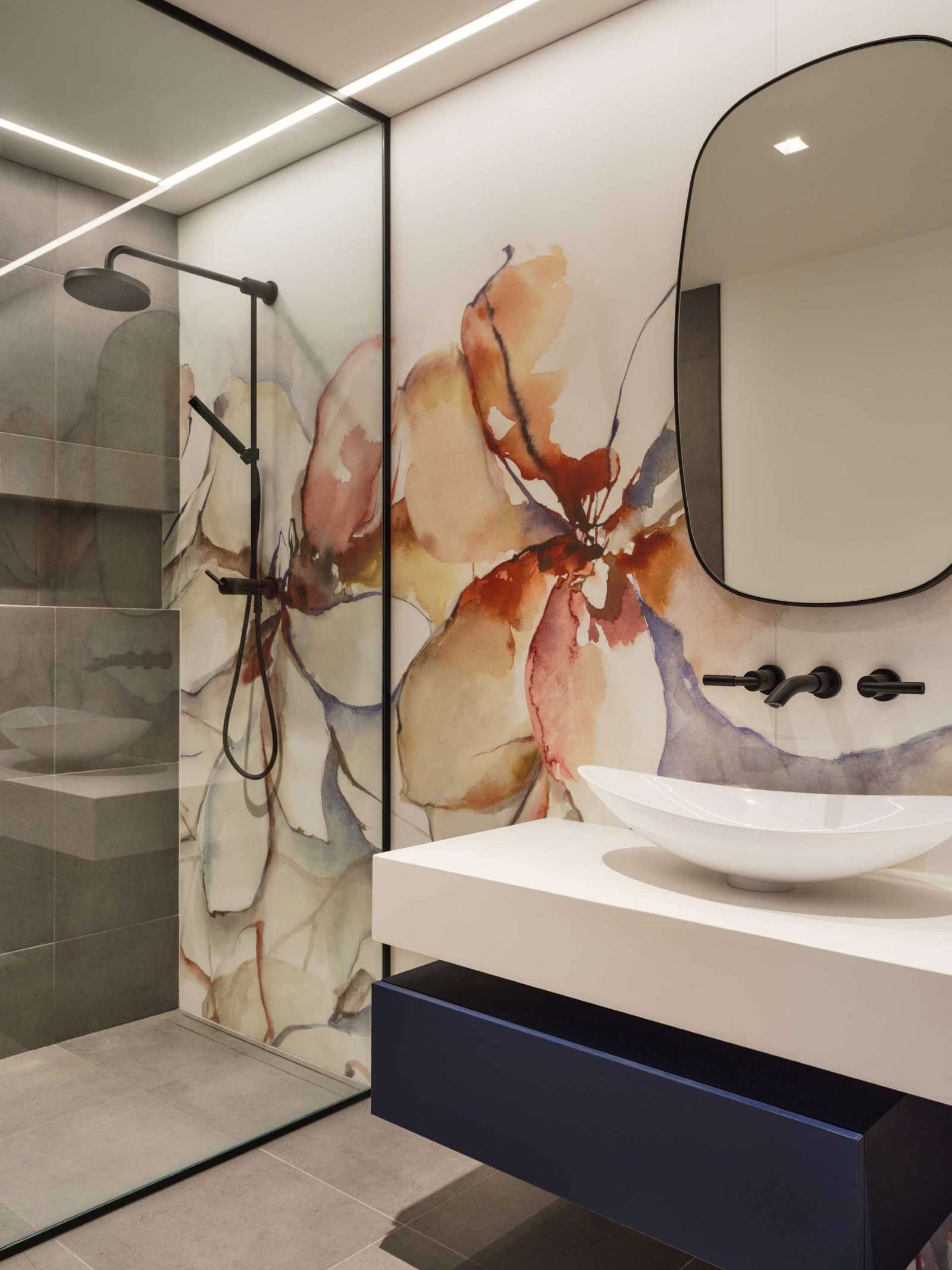 An artistic floral mural features on the wall of this bathroom, adding color to the room.