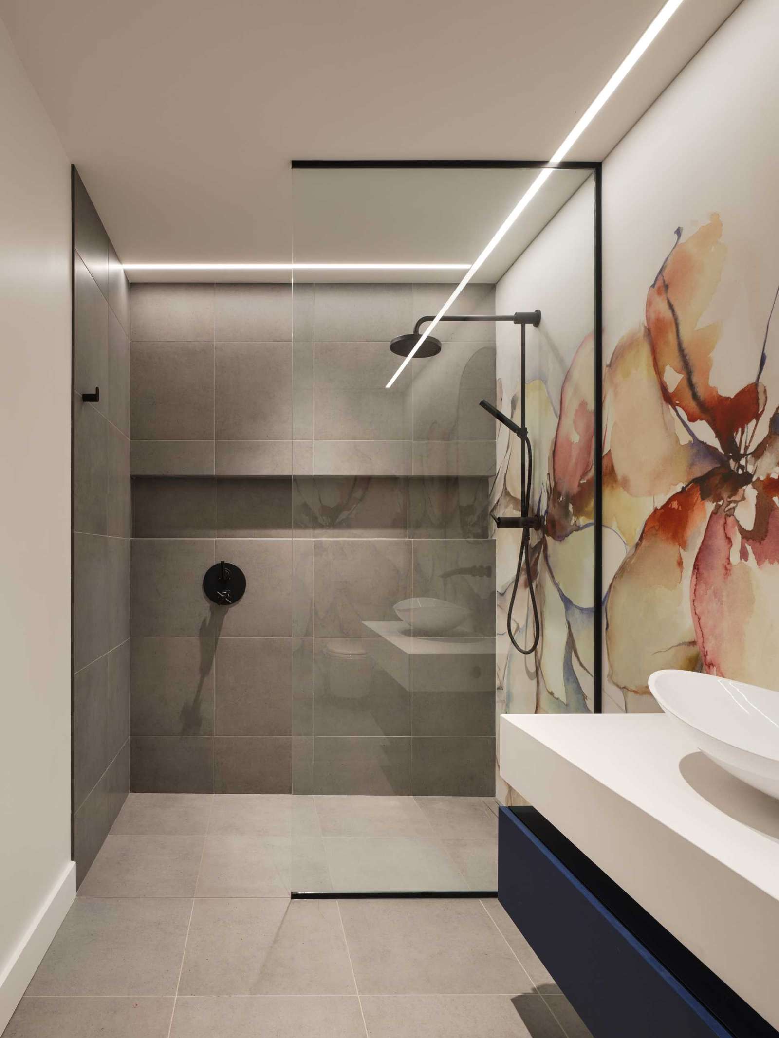 An artistic floral mural features on the wall of this bathroom, adding color to the room.