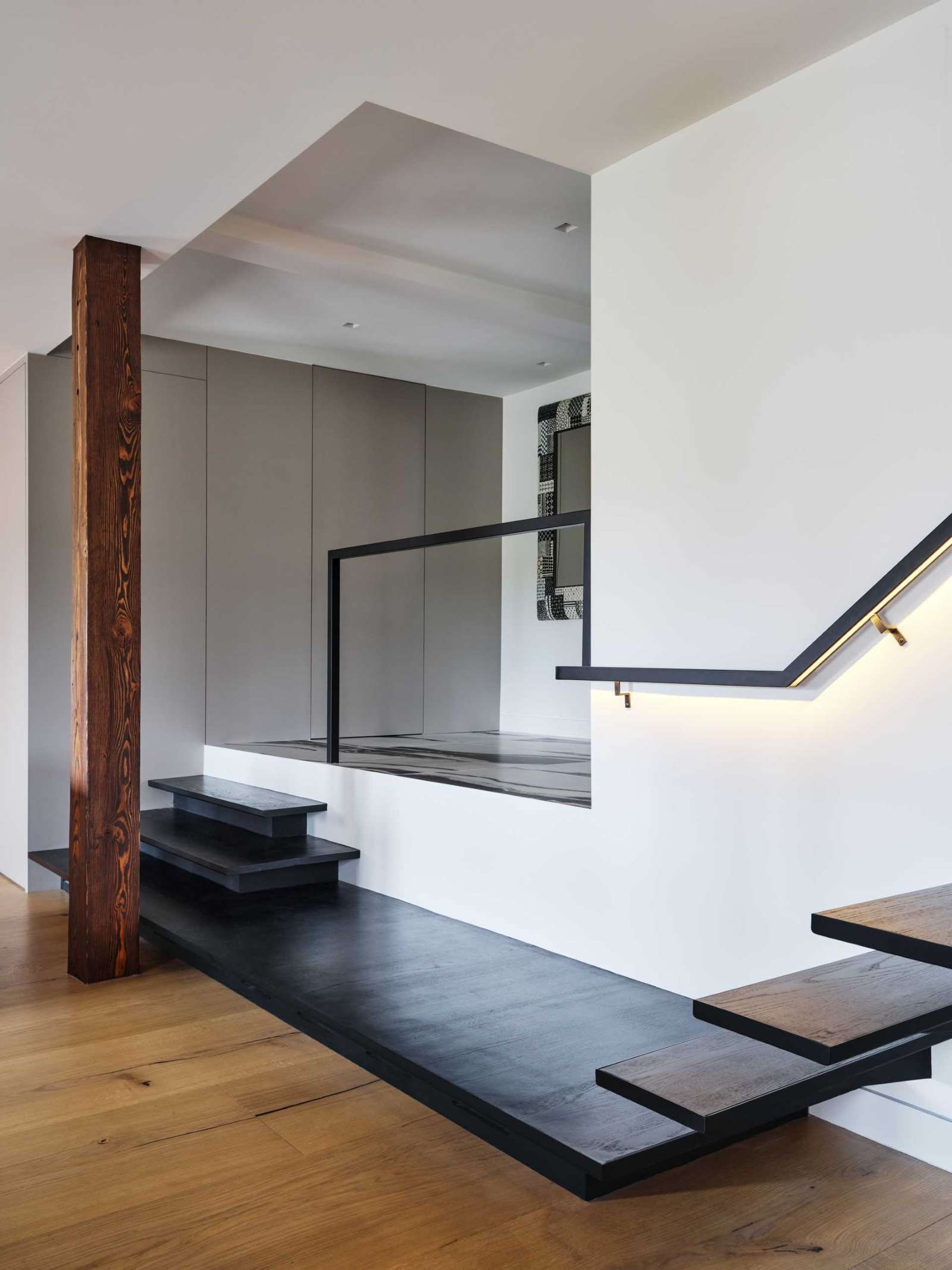 Wide oak planks and a sculptural black-metal staircase enhance the sense of grandeur in this loft apartment.