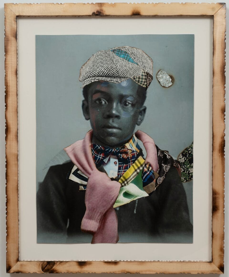 a collage of black and white photos and colorful textiles in a carved wooden frame. the photo depicts a young boy