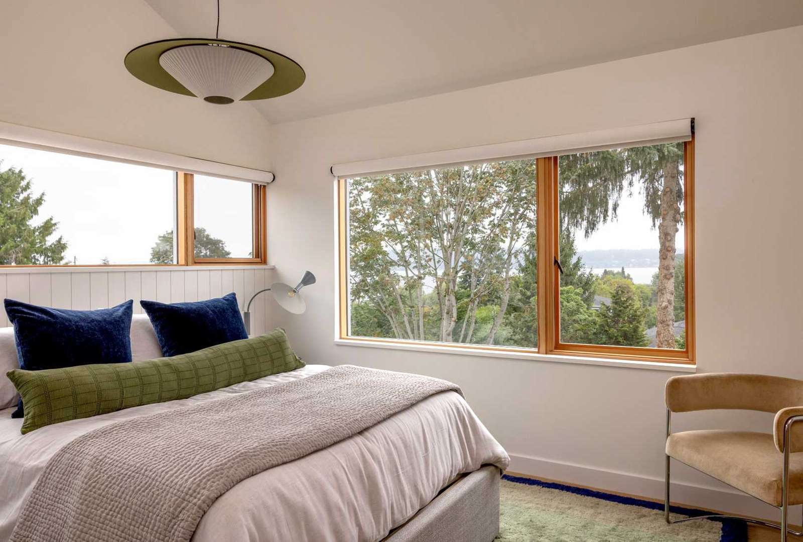 A contemporary bedroom with wood window frames.