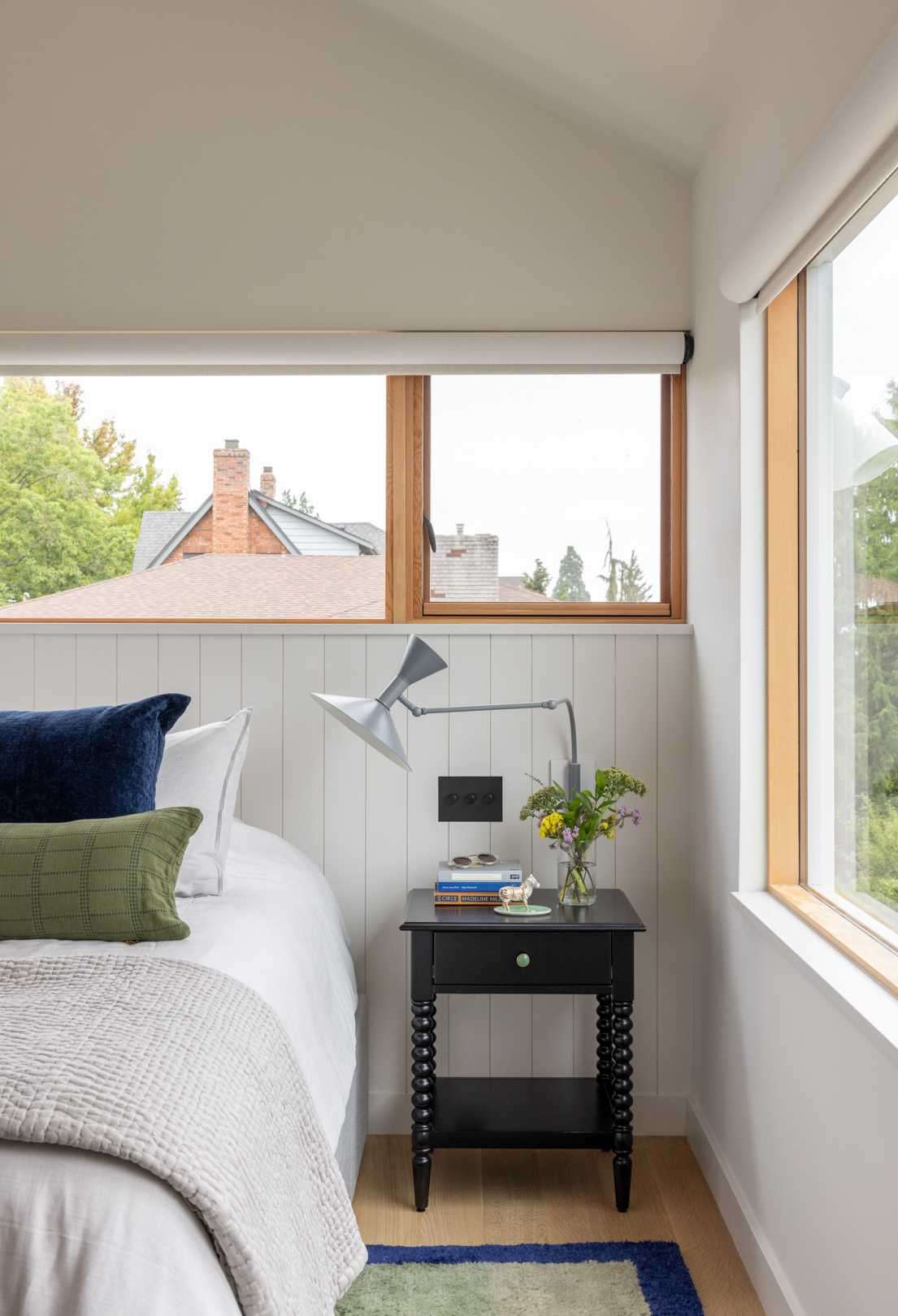 A contemporary bedroom with wood window frames.