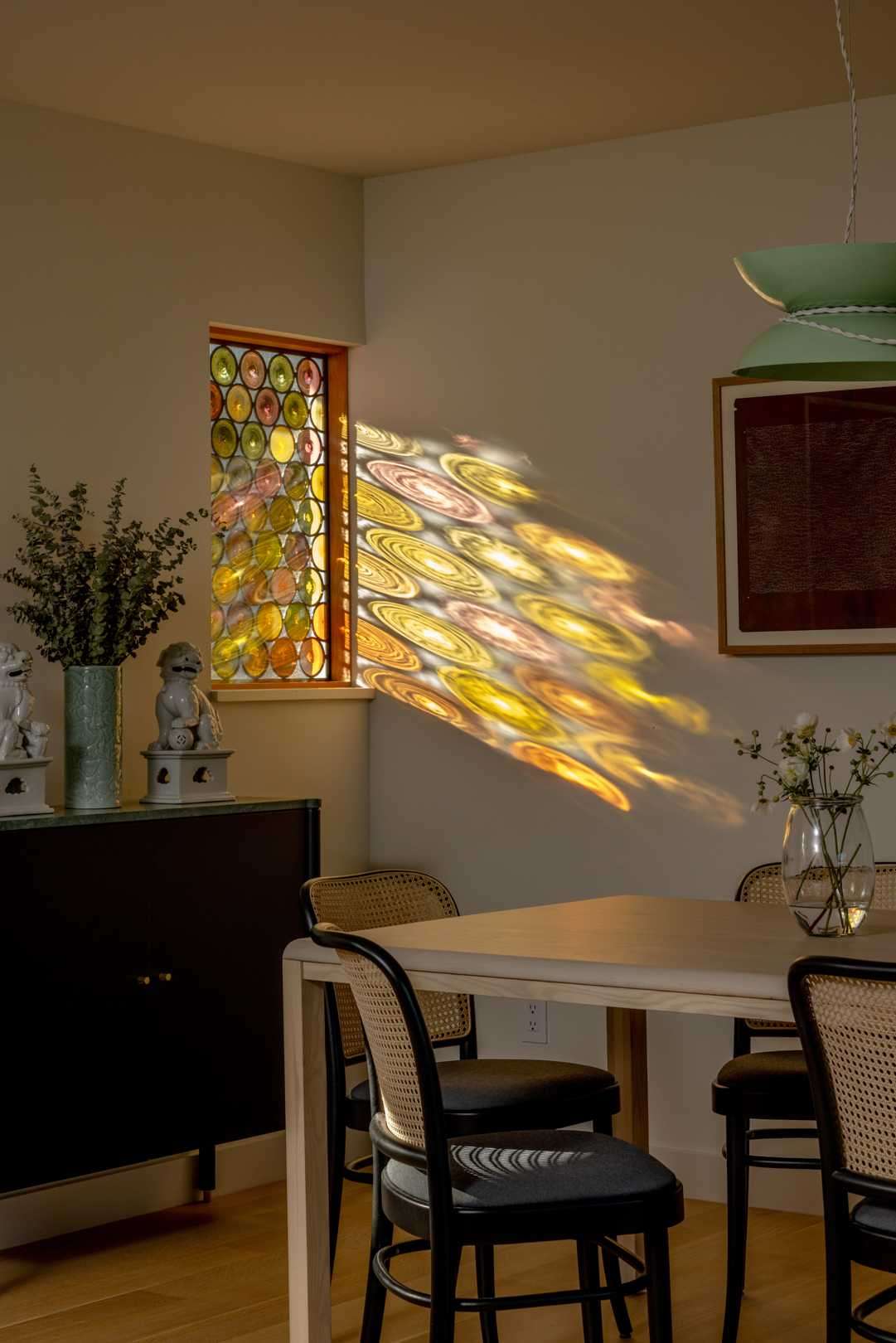 Custom stained glass windows cast playful shadows and pops of color to the new dining room.