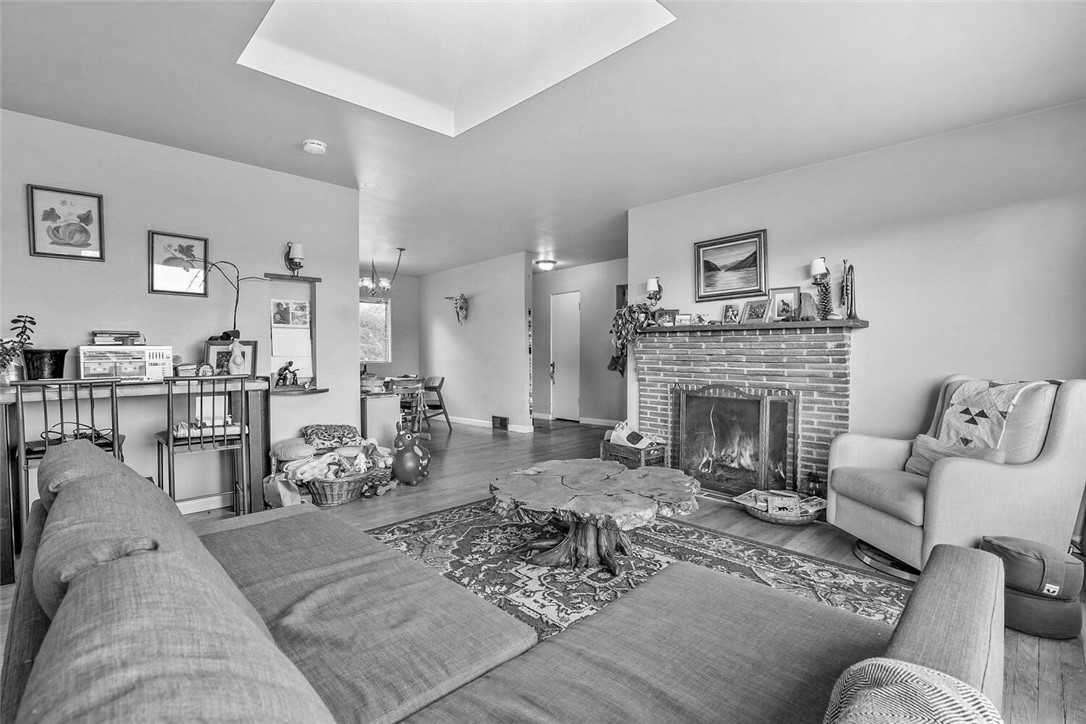 Before - a dated living room with picture window and fireplace.