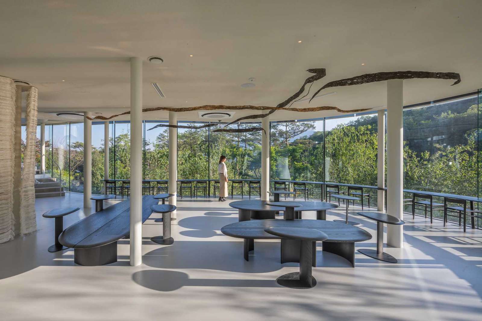 A modern cafe in South Korea, with social spaces and a green roof, was inspired by a walk in the forest.