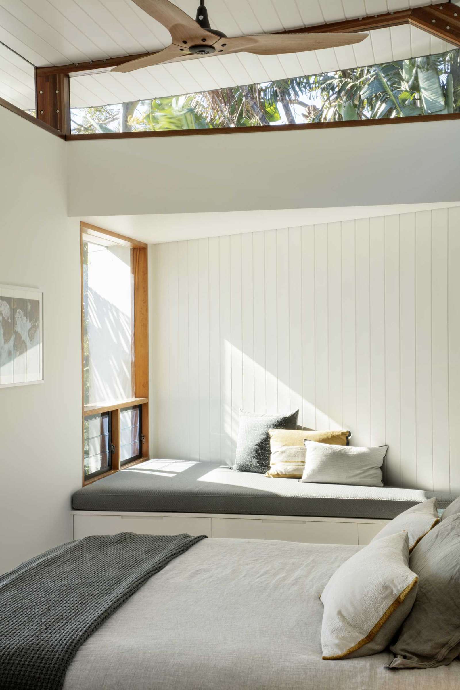 A modern bedroom with a window seat that makes the most of the triangular area.