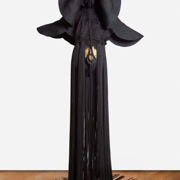 a sculpture made from black cord, thread, and metal in the form of a figure or long, dramatic garment