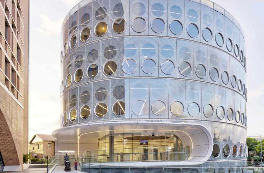 A modern library with a round design, whose exterior facade is covered in matching round windows.