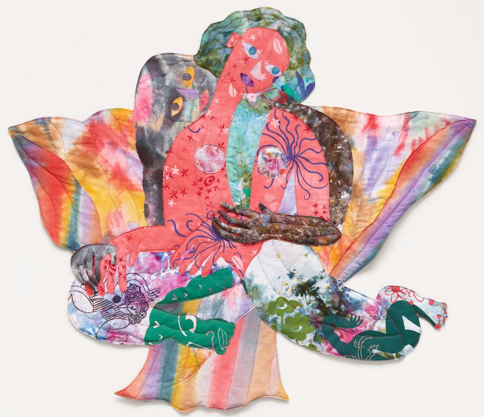 a textile portrait of a woman in vivid, patterned fabrics