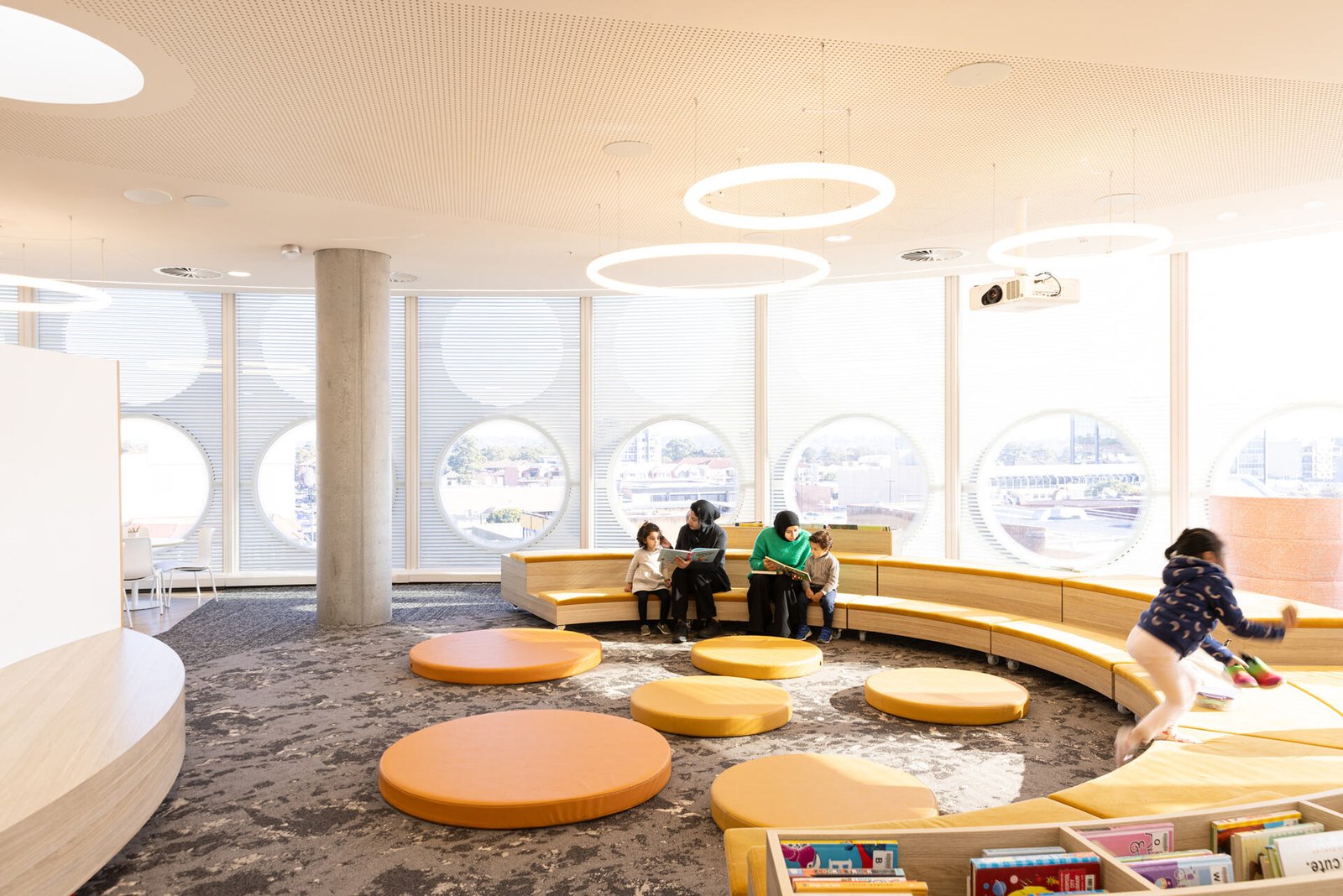 The dedicated children’s floor in this modern library provides an informal circular stage for story time that doubles as a passive play space.