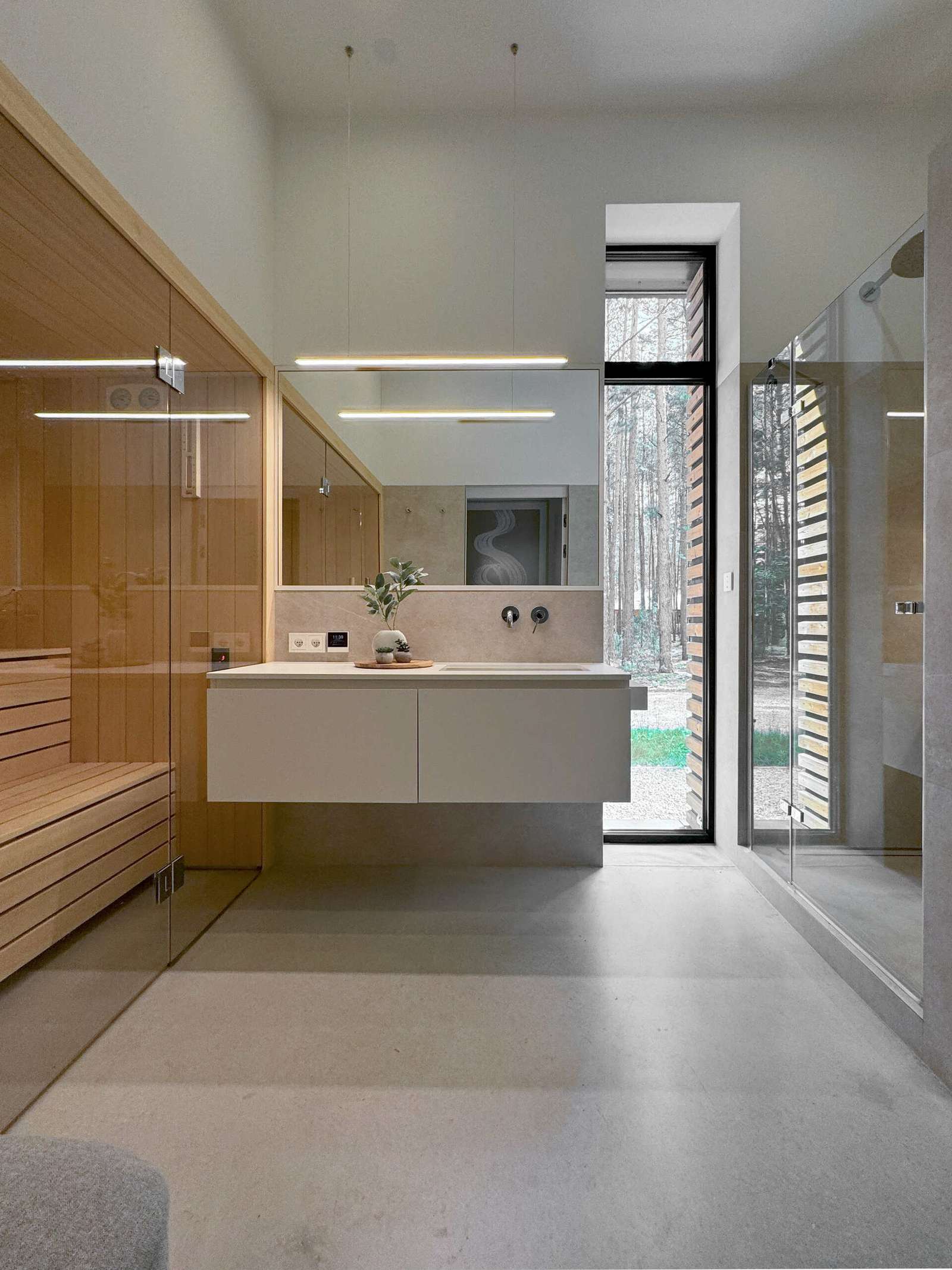 In this modern bathroom there's a walk-in shower, a floating vanity, and a sauna.