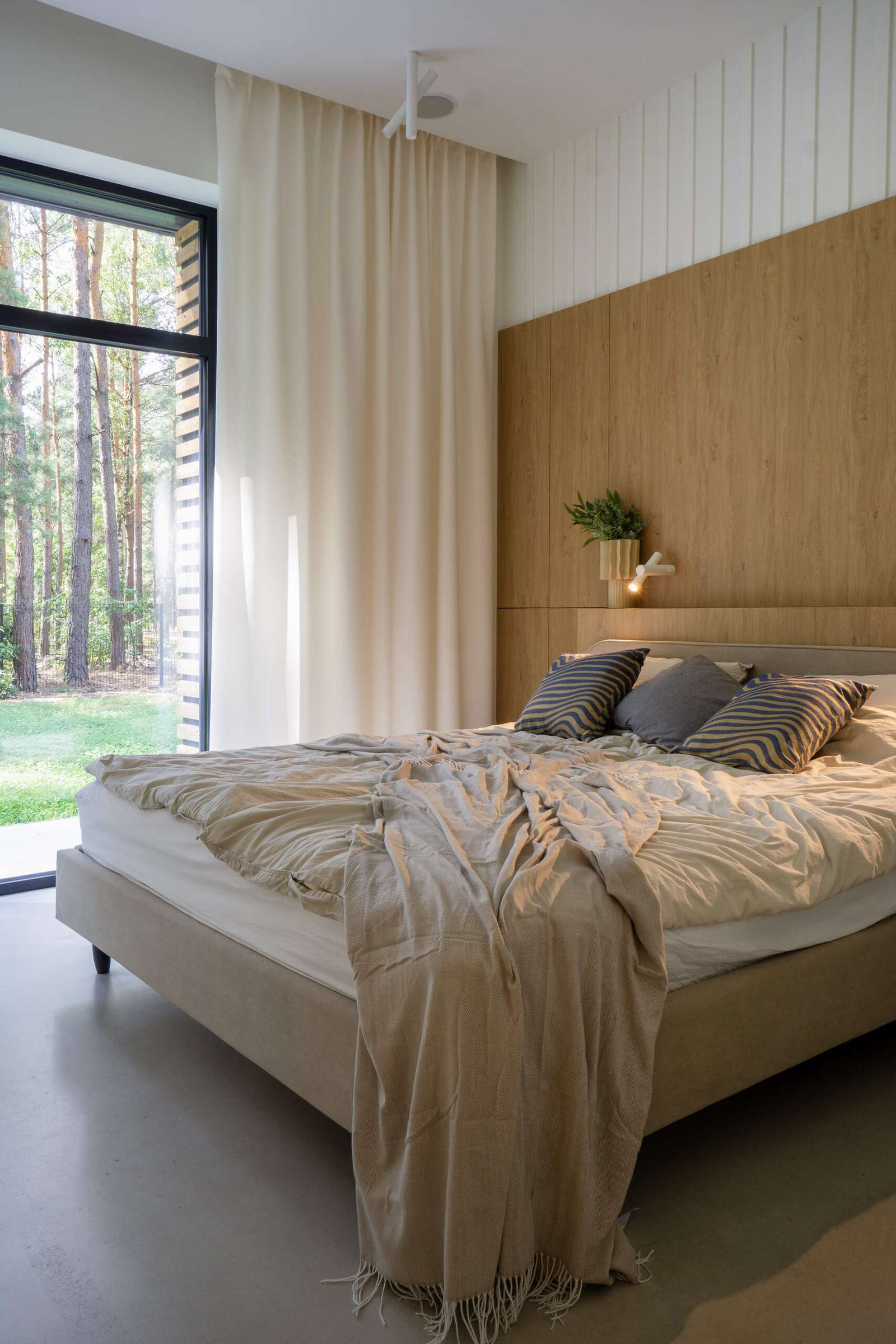 A modern bedroom with a wood headboard.