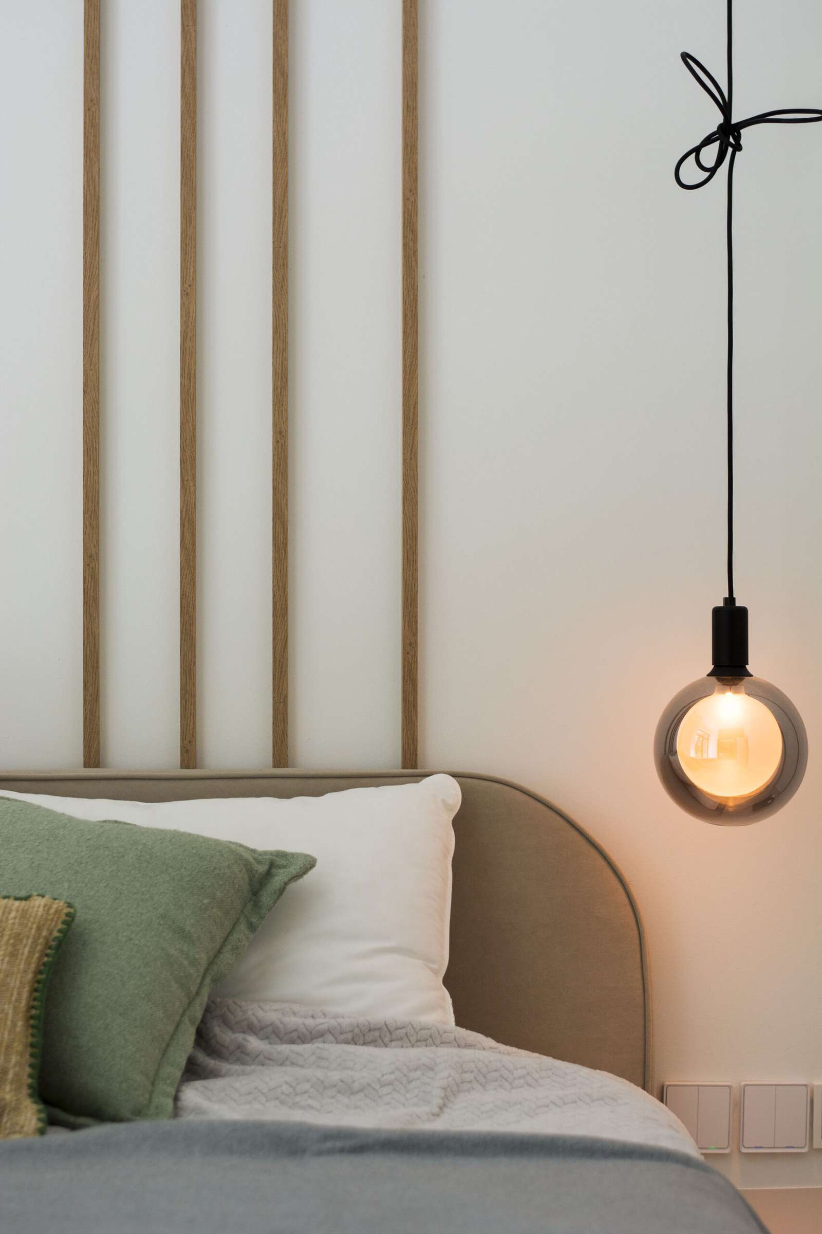 A modern bedroom with a wood strip accent.