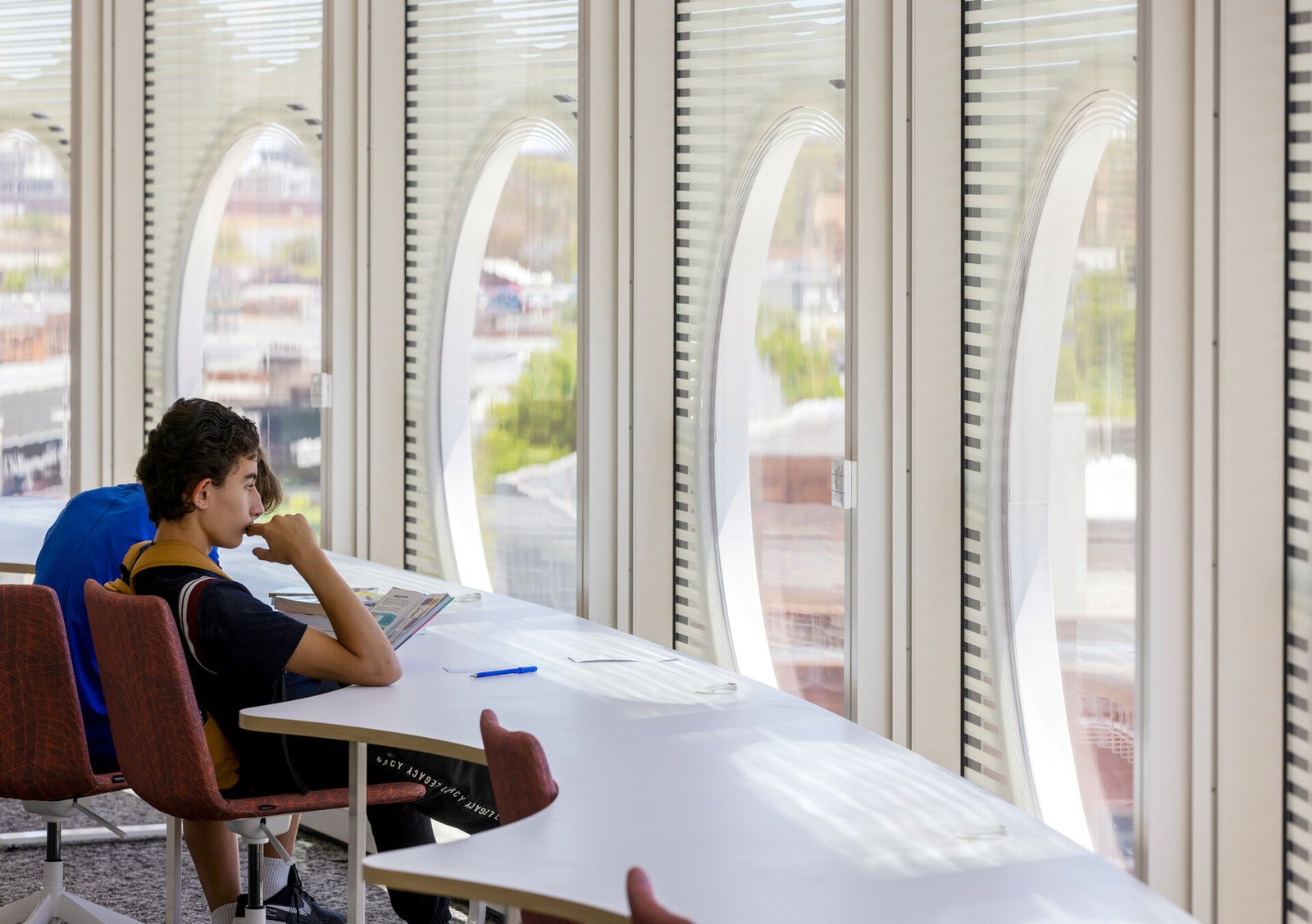 Spaces for focused study and work are built across multiple floors in a variety of formats, including views through the porthole facade.