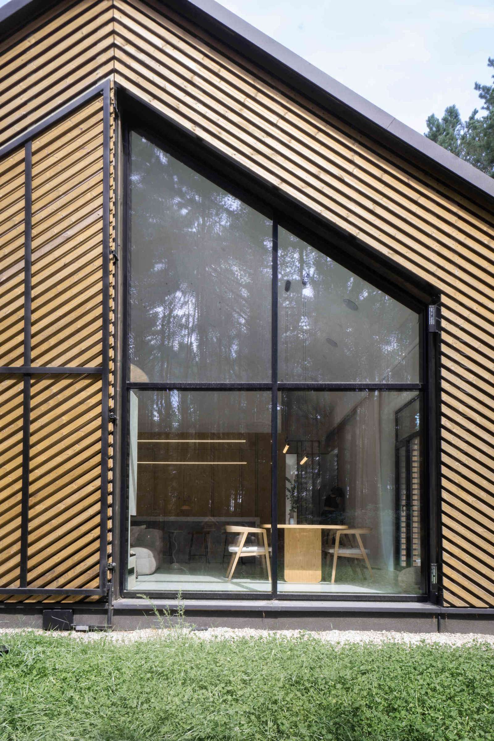 The facade of this modern home is clad in black metal and wood accents like an oversize operational screen.