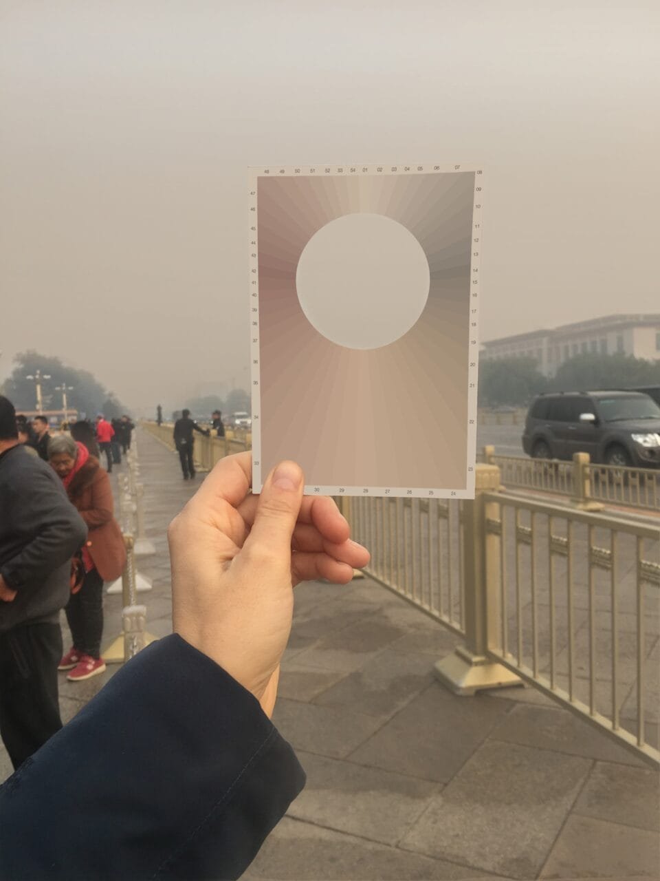 a white hand holding up a postcard to the sky